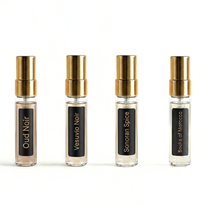 Four fragrance bottles with gold caps and black labels on a white background. Barberry Coast After Dark Fragrance Discovery Set
