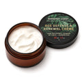 An open amber cosmetic jar filled with white cream next to its black lid, which features green tropical leaf graphics and gold text reading 'Barberry Coast Age Defense & Renewal Crème'.