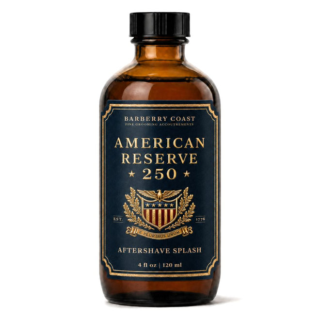 A 4 fl oz amber glass bottle of Barberry Coast American Reserve 250 Aftershave Splash with a black cap and a navy blue label with gold lettering and crest.