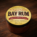Barberry Coast Bay Rum Supreme Shave Cream container on a wooden surface