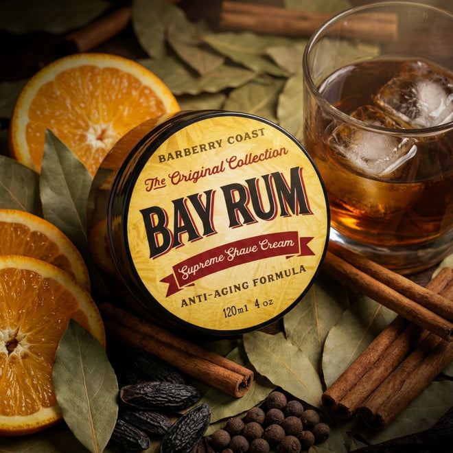 Bay rum shave cream jar with oranges, cinnamon sticks, and a glass of iced tea on a wooden surface.