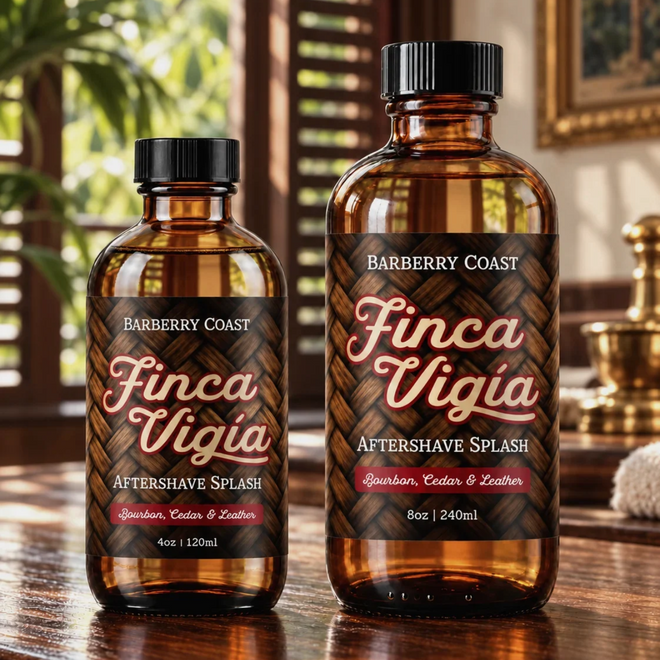 Barberry Coast Finca Vigía Aftershave Splash in 4 oz and larger 8 oz amber bottles, side by side on a wooden vanity, with sunlight and tropical greenery visible through the clear liquid.