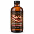 An 8oz amber glass bottle of Finca Vigia Aftershave Splash by Barberry Coast, featuring a black cap and a brown woven-wood style label with red and white lettering.
