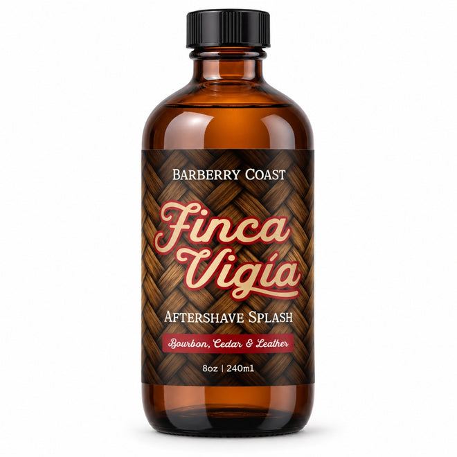 An 8oz amber glass bottle of Finca Vigia Aftershave Splash by Barberry Coast, featuring a black cap and a brown woven-wood style label with red and white lettering.