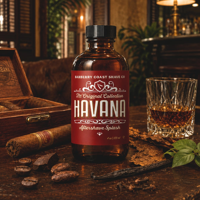 A bottle of Barberry Coast Shave Co. Havana Aftershave Splash stands on a rustic wooden table, surrounded by a cigar, an open wooden box, a glass of amber liquid, coffee beans, and dried leaves.