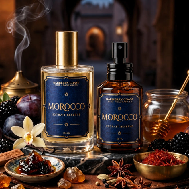 Two Morocco Extract Reserve fine fragrance bottles from Barberry Coast, one with a gold cap and one with a black spray top, styled with blackberries, star anise, honey, and a incense burner on a dark marble surface.