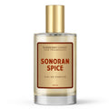 A bottle of Sonoran Spice Eau de Parfum Cologne by Barberry Coast. The bottle is clear with a gold foil label, 100ml in size on a white background.